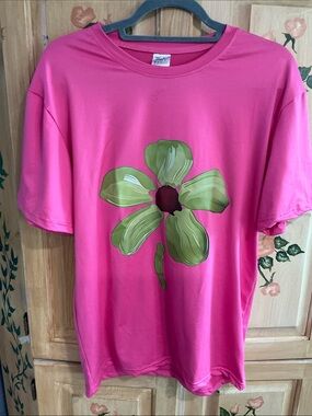 Unisex tshirt in a gorgeous hot pink with a green painted flower in the middle